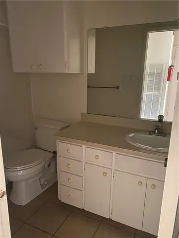 a bathroom with a granite countertop toilet sink and mirror