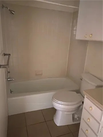 a white toilet sitting next to a bath tub