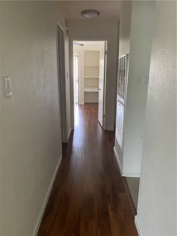 a view of a hallway with wooden floor