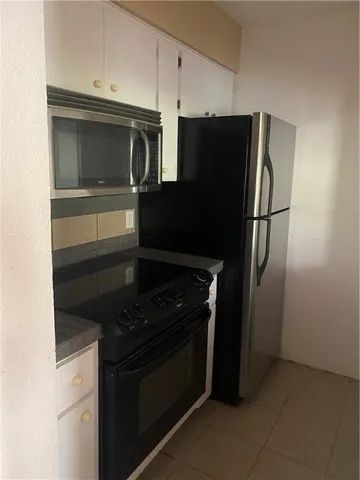 a kitchen with a refrigerator stove and microwave
