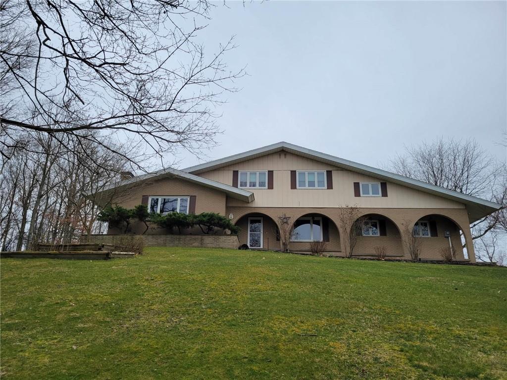 a front view of a house with yard and green space