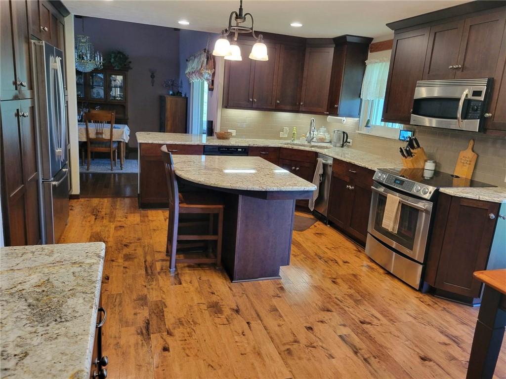 1855 Alamae Lakes Road Washington, PA 15301 - Photo 4 of 21 a kitchen with kitchen island granite countertop wooden cabinets a stove top oven a sink and dishwasher