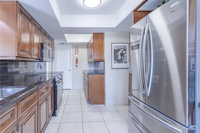 a kitchen with stainless steel appliances granite countertop a refrigerator and a sink