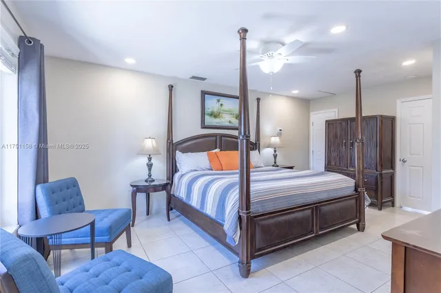 a bedroom with a bed table and chairs