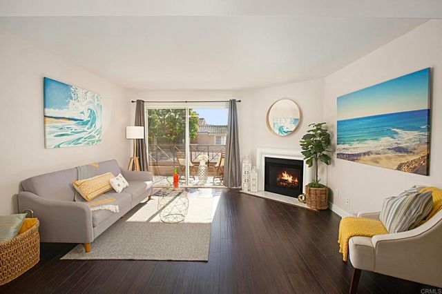 a living room with furniture a fireplace and a large window