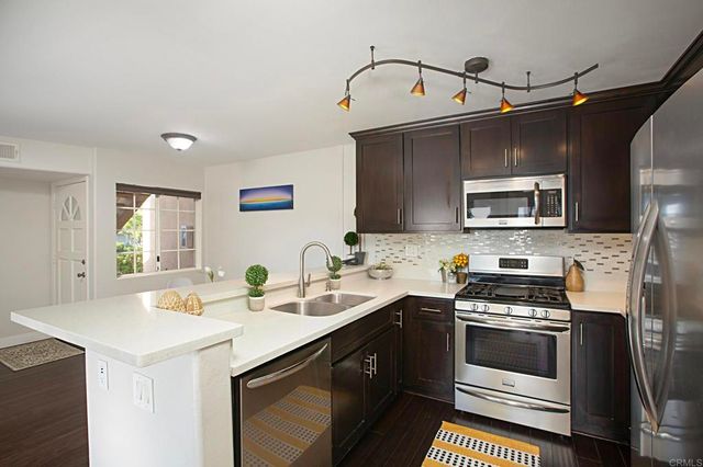 a kitchen with a sink cabinets and stainless steel appliances