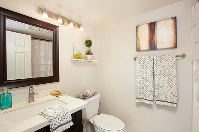 a bathroom with a sink toilet and mirror