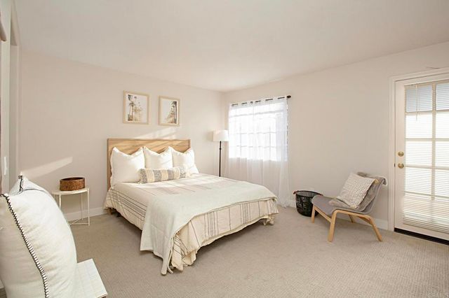 a bedroom with a bed chair and window