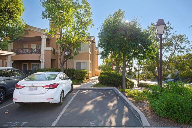 a white house covered with tall trees