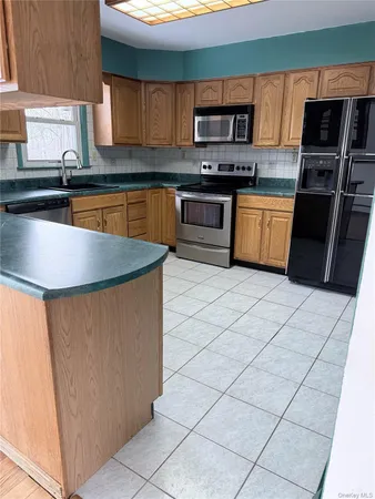 a kitchen with stainless steel appliances granite countertop a sink stove refrigerator and a microwave