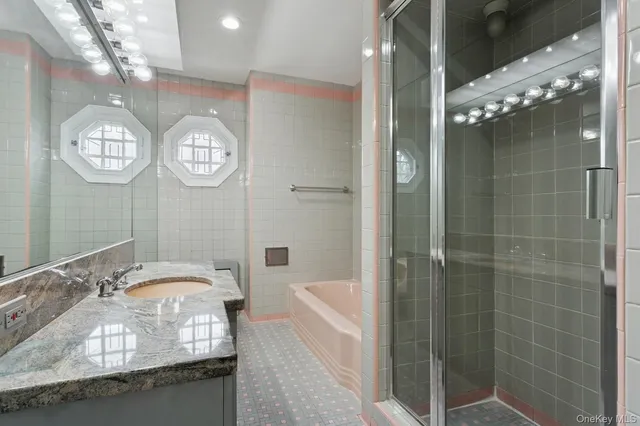 a bathroom with a granite countertop sink a mirror and a shower