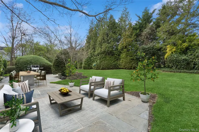 a view of a patio with couches table and chairs and potted plants