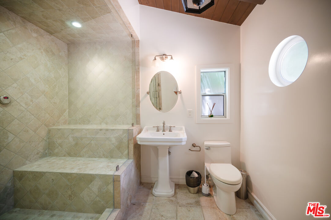 503 North Greencraig Road Los Angeles, CA 90049 - Photo 49 of 59 a bathroom with a toilet a sink and mirror