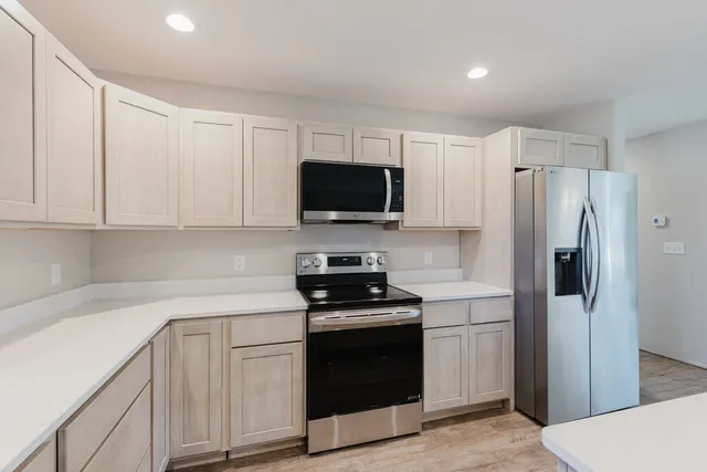 a kitchen with white cabinets and stainless steel appliances