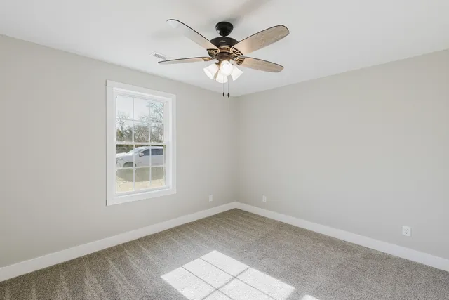 an empty room with a window and a fan