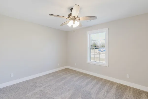 an empty room with a window and a fan