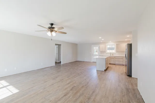 a view of a room with wooden floor and a kitchen