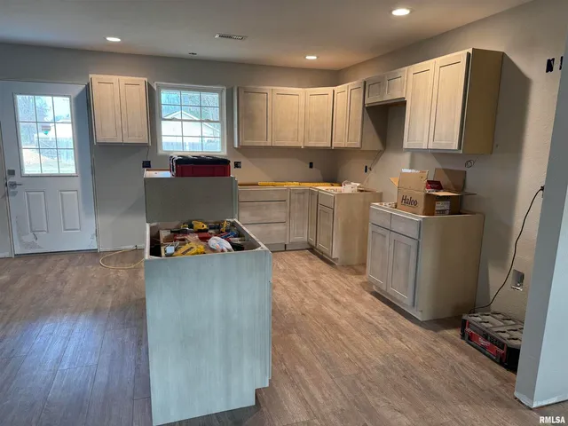 a kitchen with cabinets and wooden floor