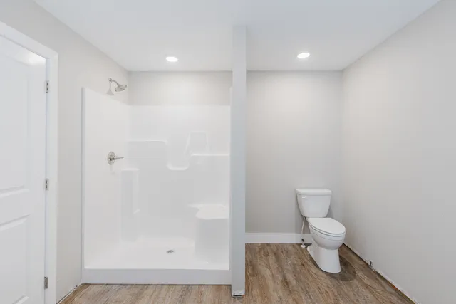 a bathroom with a toilet and a shower