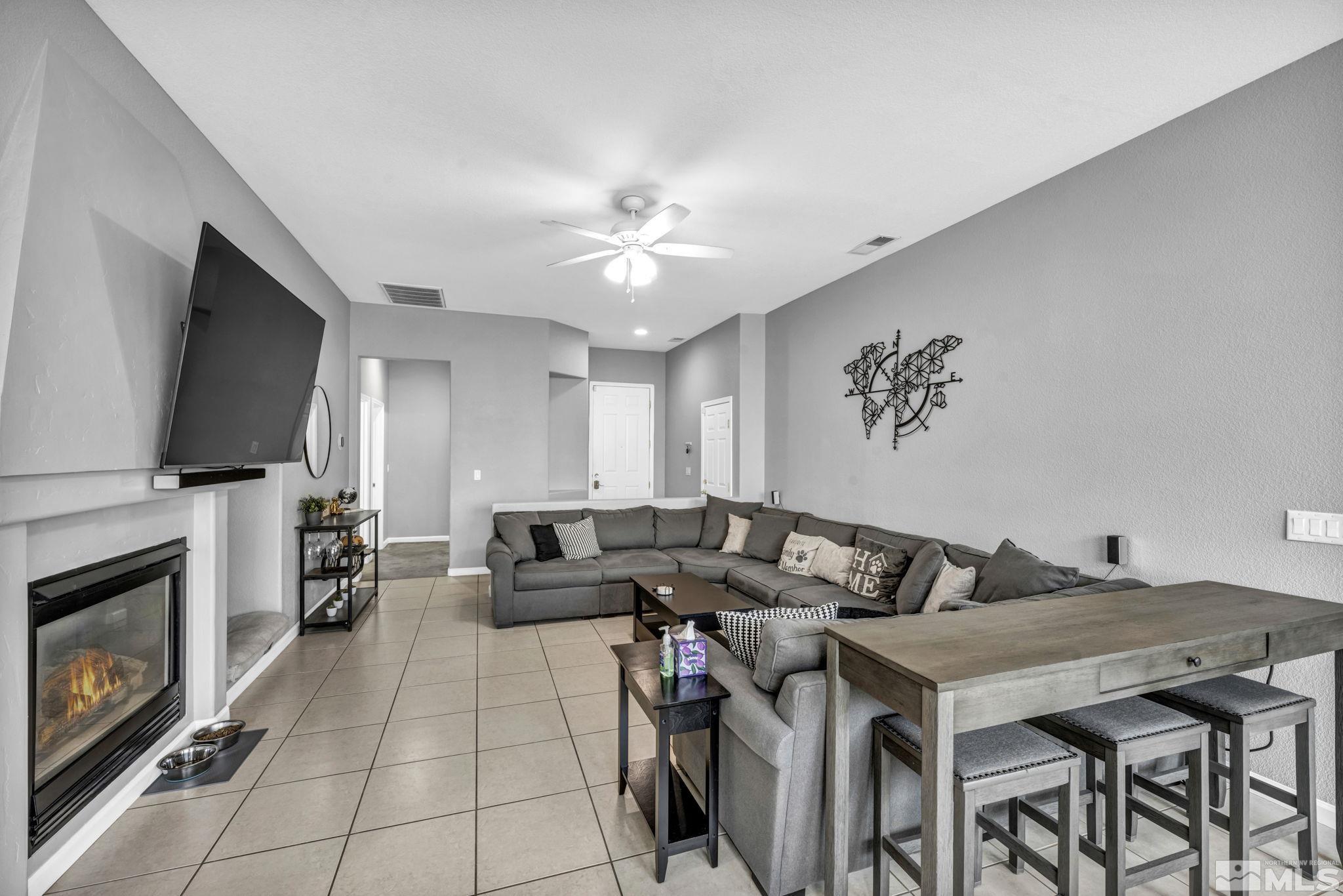 10518 French Meadows Way Reno, NV 89521 - Photo 25 of 34 a living room with furniture a fireplace and a flat screen tv