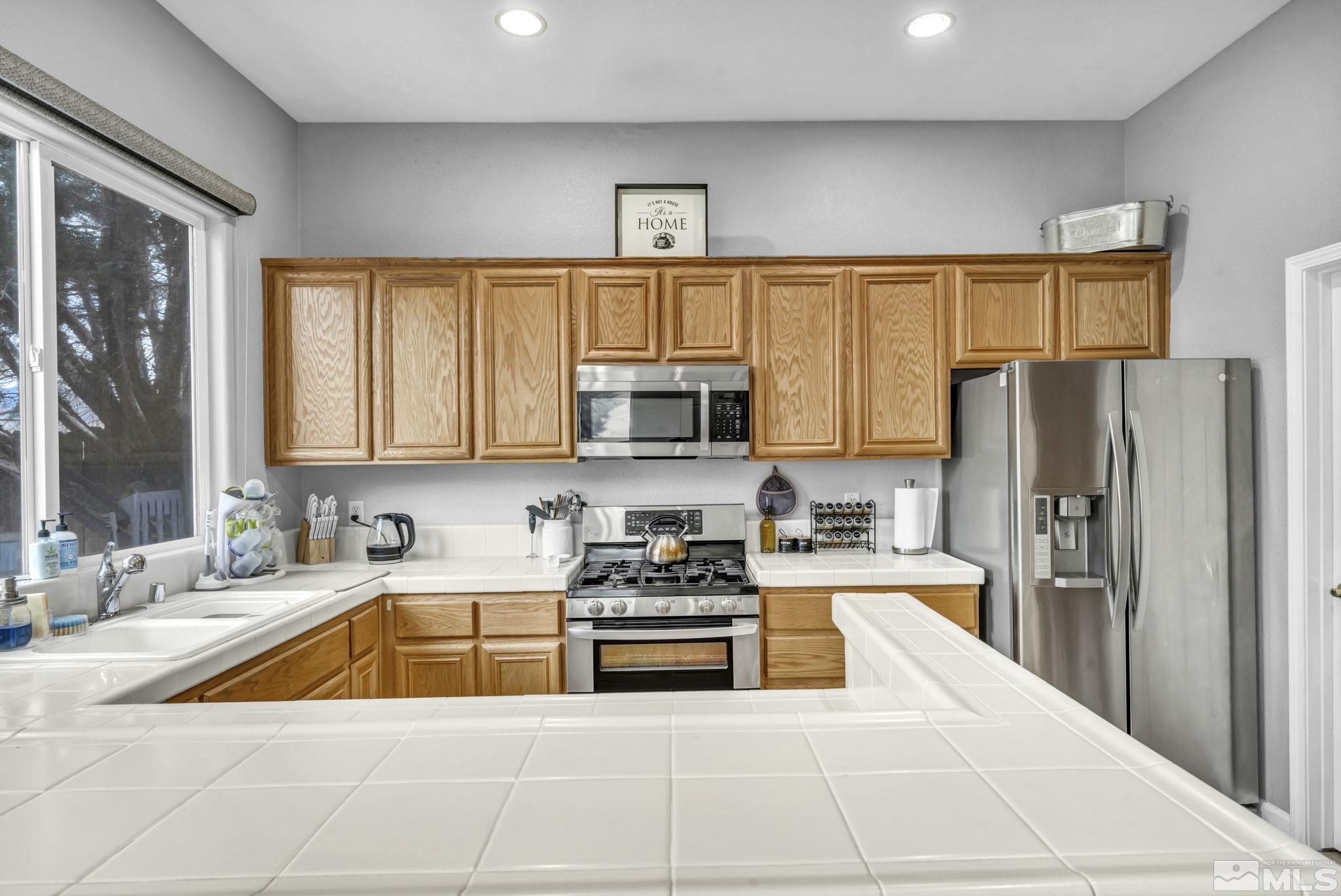 10518 French Meadows Way Reno, NV 89521 - Photo 32 of 34 a kitchen with stainless steel appliances a refrigerator a sink a stove a microwave and cabinets