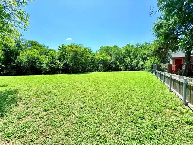 a view of yard with grass and trees