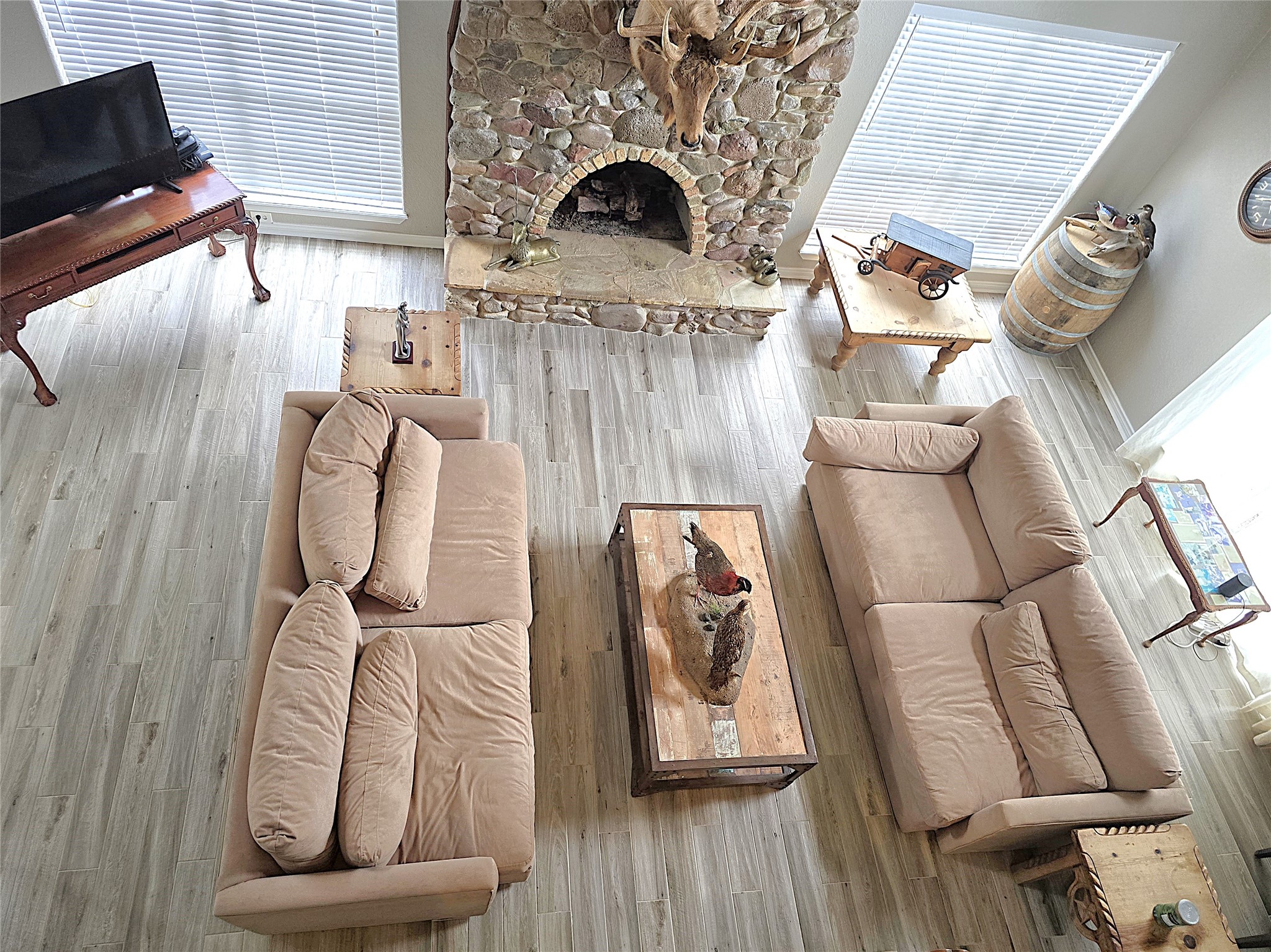560 Brandon Road Conroe, TX 77302 - Photo 3 of 45 Spacious living room with a cozy stone fireplace, natural light, and elegant hardwood floors, perfect for relaxation and entertaining.