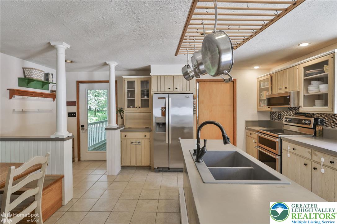 60 Sassafras Road Lehighton, PA 18235 - Photo 14 of 36 A well-equipped kitchen features a large island with a double basin sink and stainless steel appliances.
