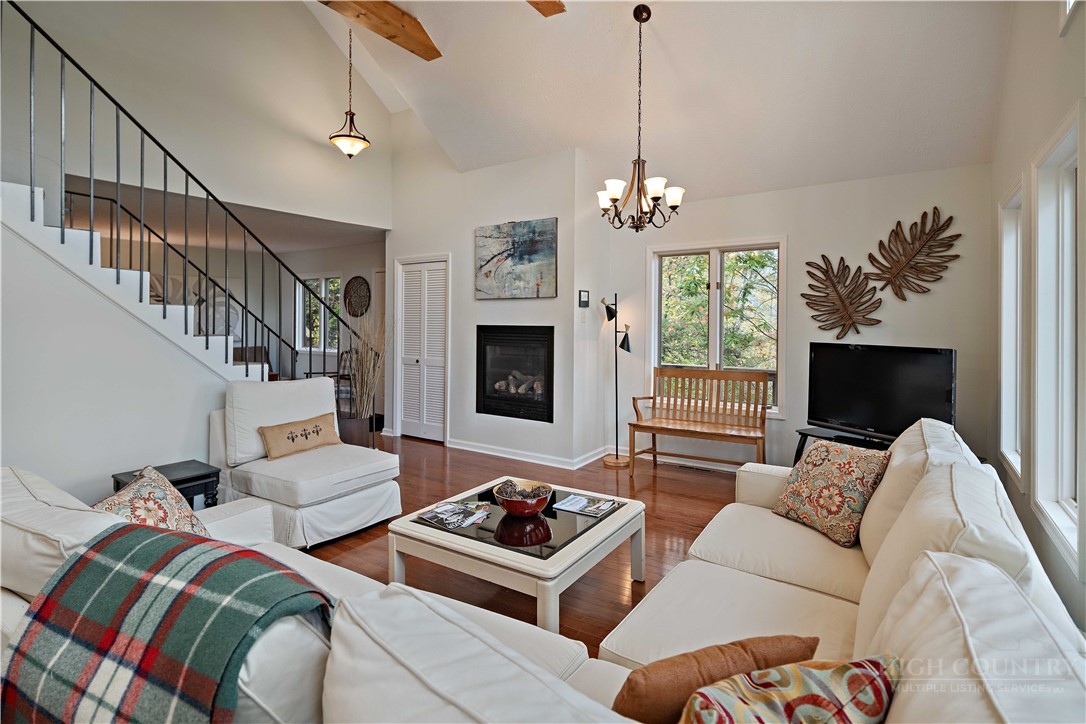 265 Leatherwood Road Banner Elk, NC 28604 - Photo 11 of 42 a living room with furniture ceiling fan and a fireplace
