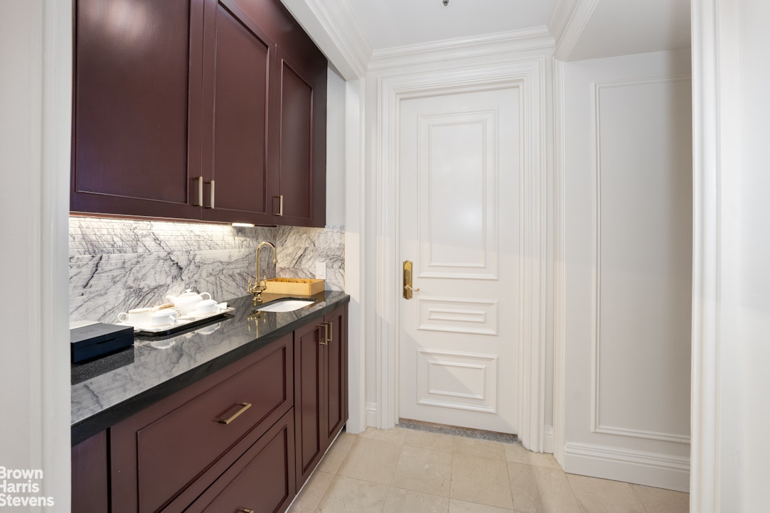 2 East 55th Street, Unit 835/31 Manhattan, NY 10022 - Photo 7 of 14 a kitchen with granite countertop cabinets and sink
