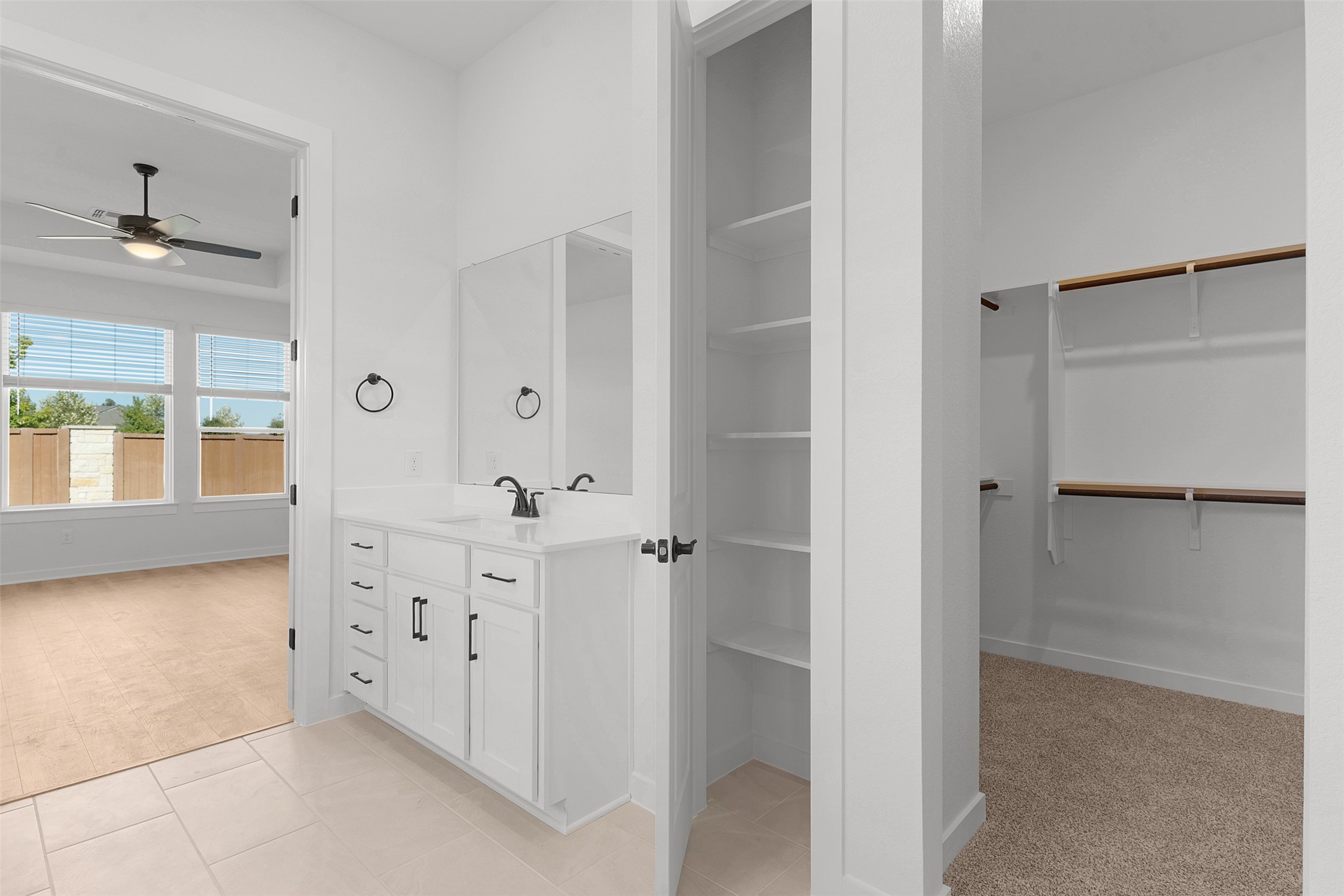 328 Ridgewell Loop Georgetown, TX 78633 - Photo 19 of 28 Bathroom featuring a walk in closet, vanity, light tile patterned floors, and light colored carpet