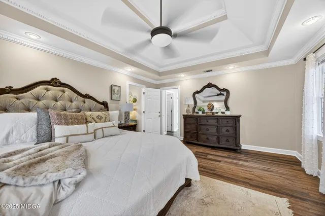 a bedroom with a bed and dresser with the wooden floor
