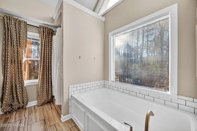 a bedroom with a large bed and wooden floor
