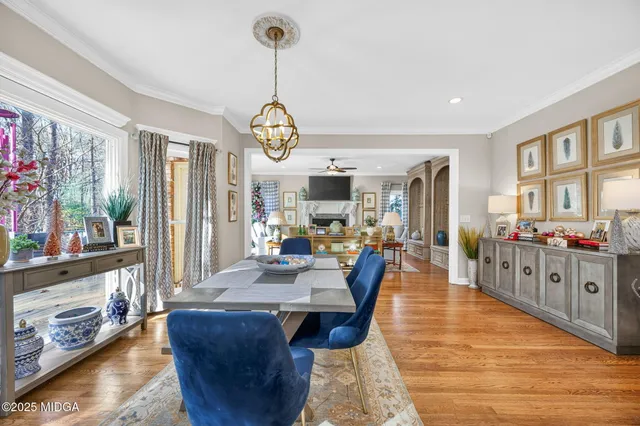 a view of a dining room and livingroom with furniture wooden floor a chandelier
