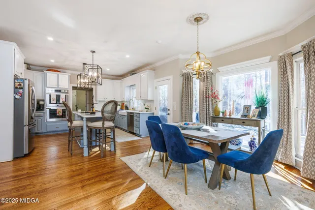 a dining room with furniture a chandelier and wooden floor