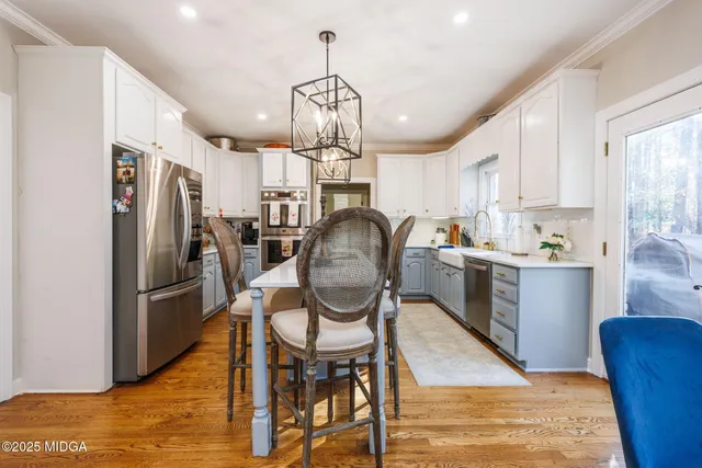 a kitchen with stainless steel appliances granite countertop a sink refrigerator and cabinets