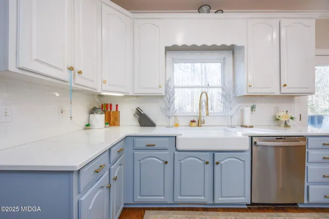 a kitchen with cabinets appliances a sink and a window