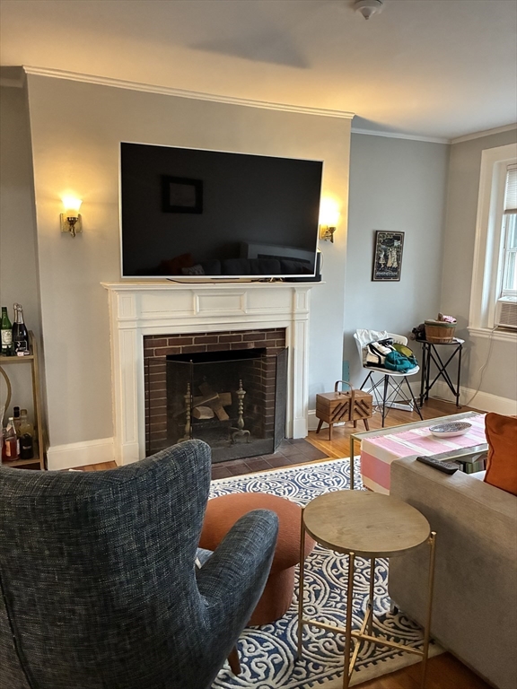 32 Shepard Street, Unit 24 Cambridge, MA 02138 - Photo 3 of 15 a living room with furniture a flat screen tv and a fireplace
