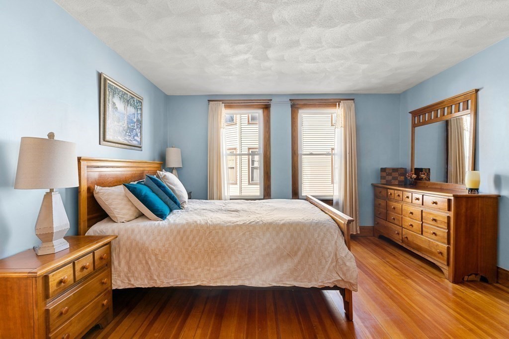 86 Howard Street, Unit 1 Waltham, MA 02451 - Photo 22 of 40 a bedroom with a bed and a dresser next to a window
