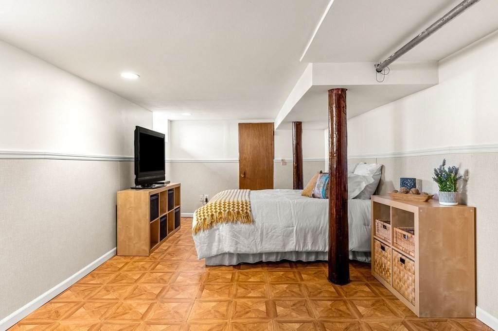 86 Howard Street, Unit 1 Waltham, MA 02451 - Photo 32 of 40 a bedroom with a bed and a flat screen tv