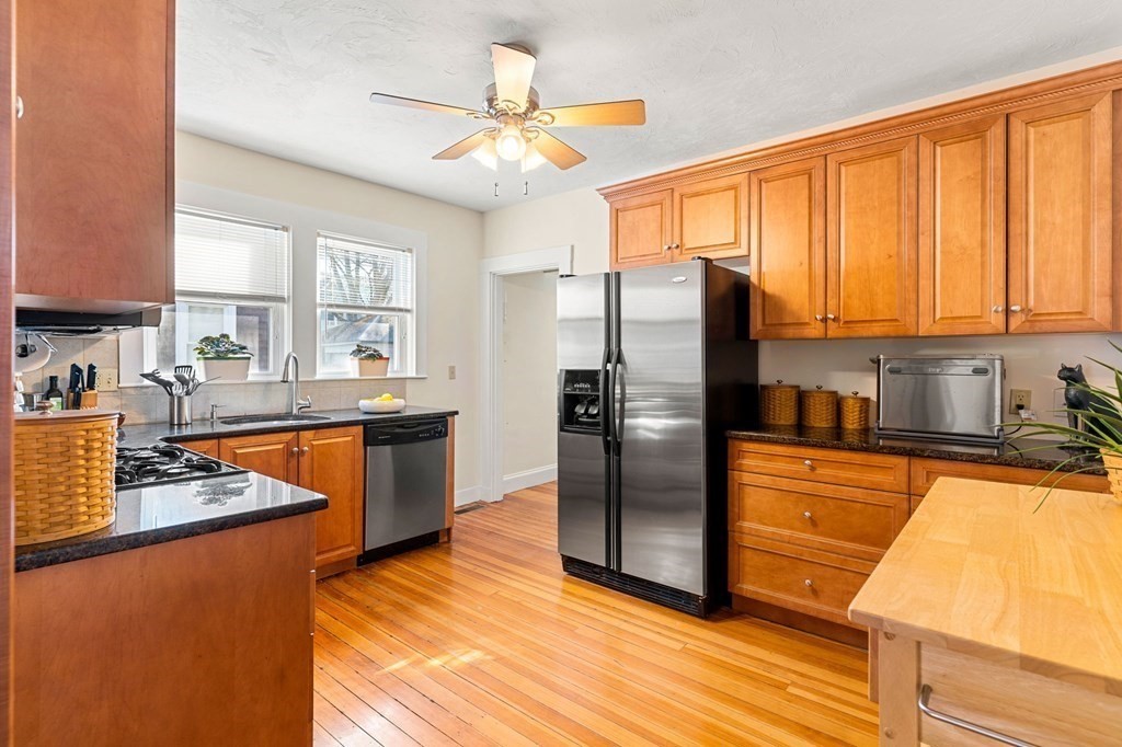 86 Howard Street, Unit 1 Waltham, MA 02451 - Photo 8 of 40 a kitchen with stainless steel appliances granite countertop a refrigerator a sink dishwasher a stove and white countertops with wooden floor