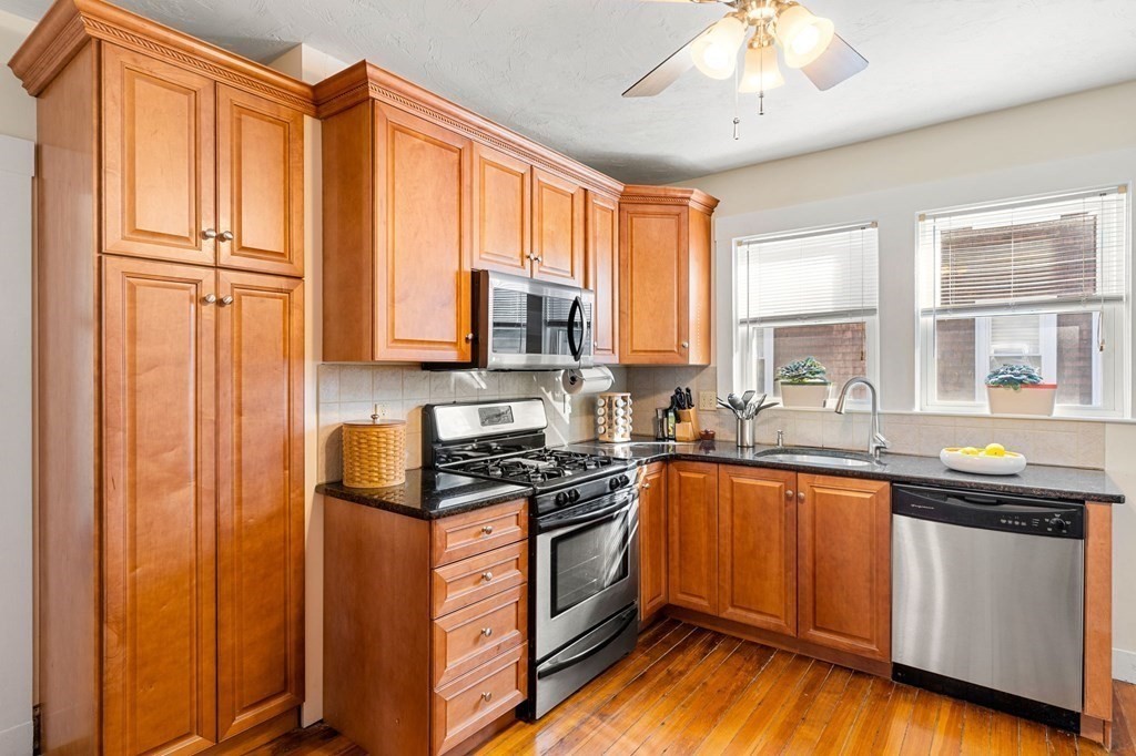86 Howard Street, Unit 1 Waltham, MA 02451 - Photo 9 of 40 a kitchen with stainless steel appliances granite countertop a stove a sink and a refrigerator