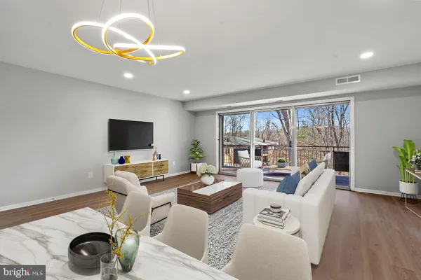 a living room with furniture a flat screen tv and a large window