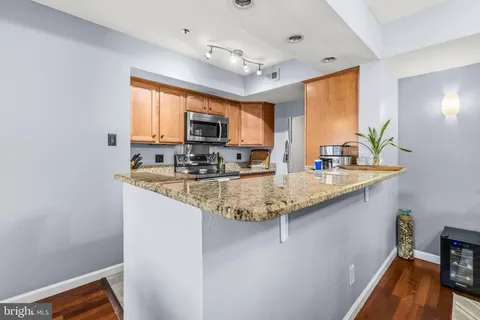 a kitchen with stainless steel appliances granite countertop a sink a stove and a refrigerator