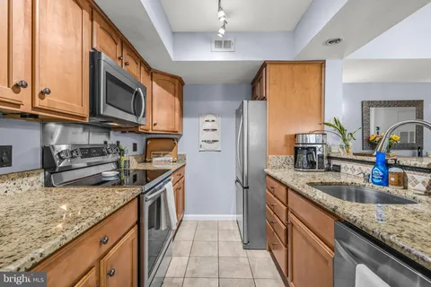 a kitchen with stainless steel appliances granite countertop a sink and a stove
