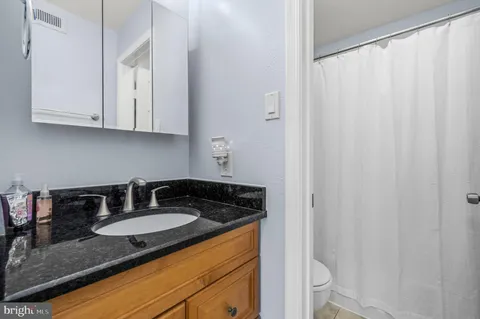 a bathroom with a granite countertop sink and a mirror