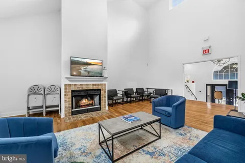 a living room with furniture a flat screen tv and a fireplace