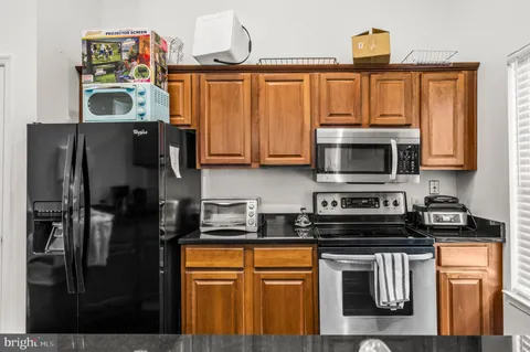 a kitchen with stainless steel appliances granite countertop a refrigerator stove and microwave