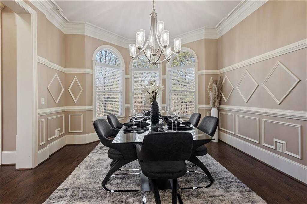1859 Mountain Shadow Smoke Rise, GA 30087 - Photo 31 of 75 a dining room with wooden floor a chandelier a wooden table and chairs