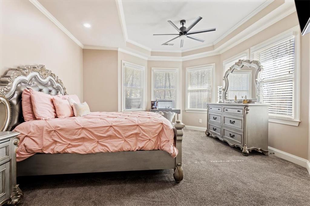 1859 Mountain Shadow Smoke Rise, GA 30087 - Photo 44 of 75 a bedroom with a bed a chandelier and a flat tv screen